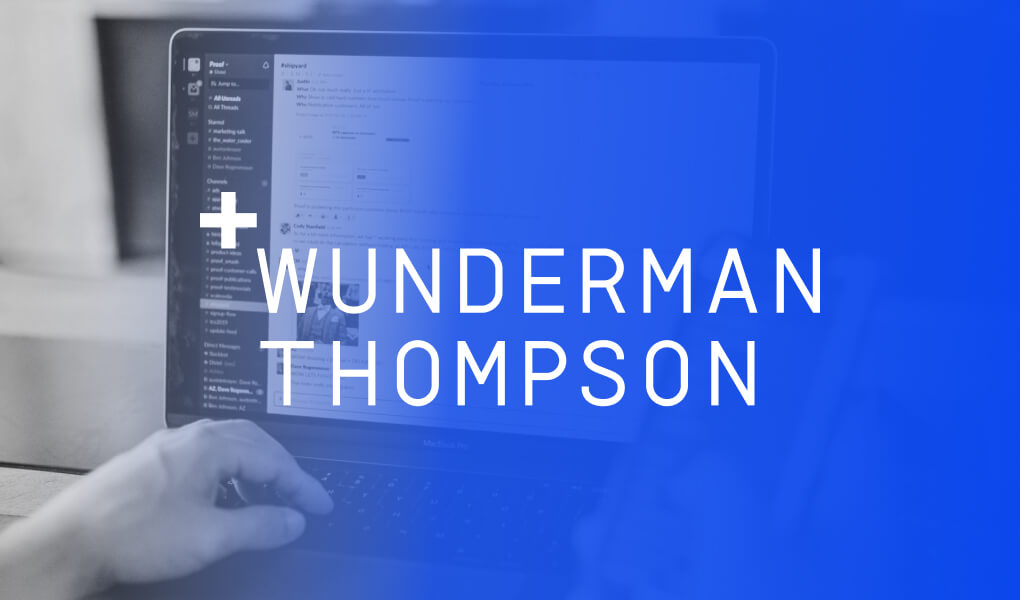 A person typing on a laptop with the Wunderman Thompson logo on the side.