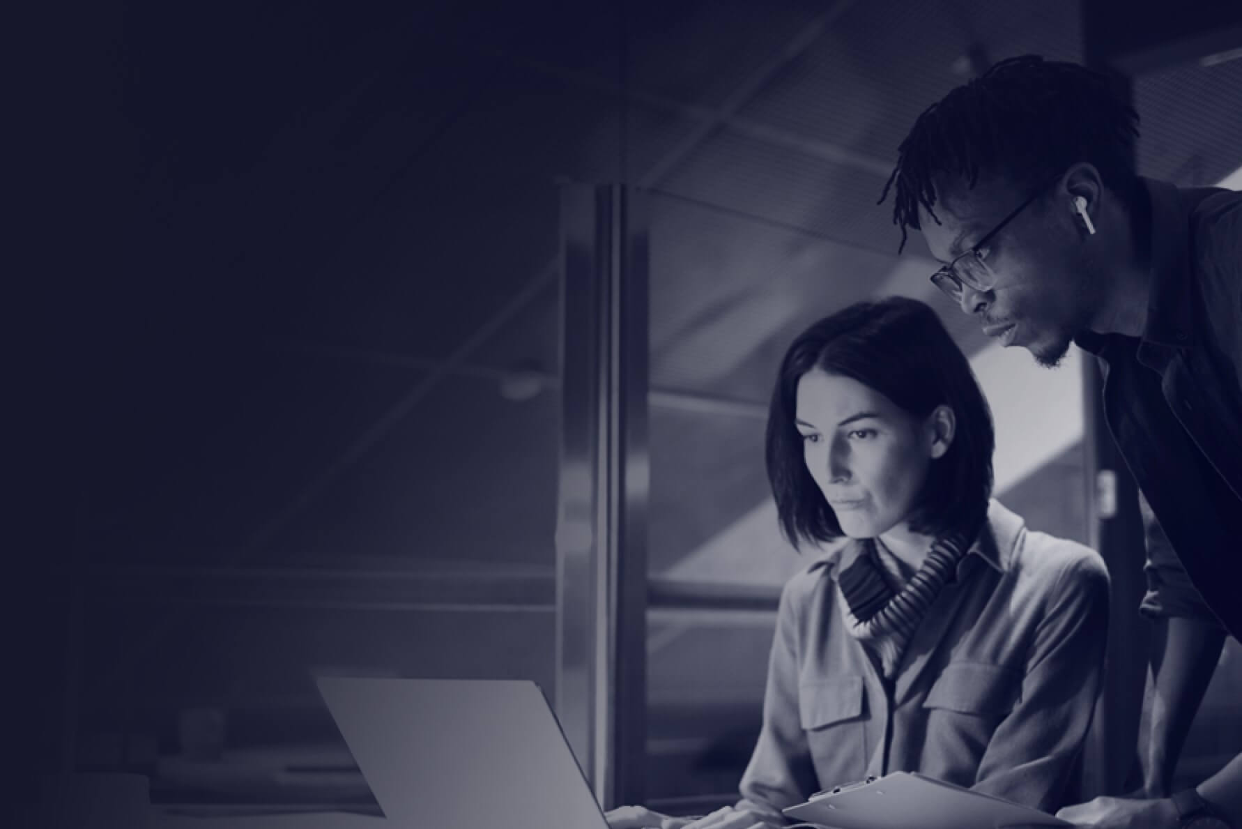 A woman and a man looking at a laptop